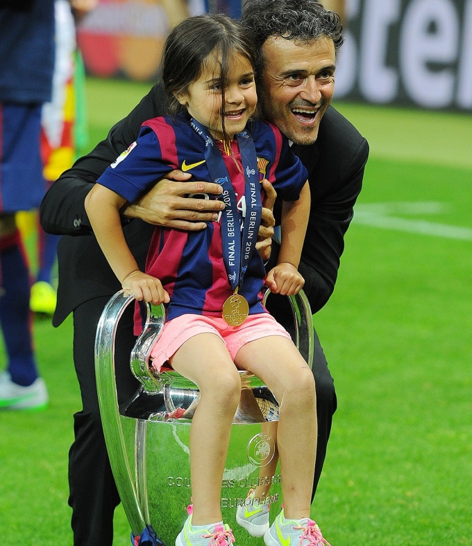 Enrique bế con gái Xana ngồi lên chiếc Cup tai voi - danh hiệu Champions League khi cùng Barca vô địch năm 2015.