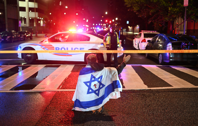 Một người khoác cờ Israel bên ngoài hiện trường vụ nổ súng ở bảo tàng Do Thái tại thủ đô Washington, Mỹ, đêm 21/5. Ảnh: AFP