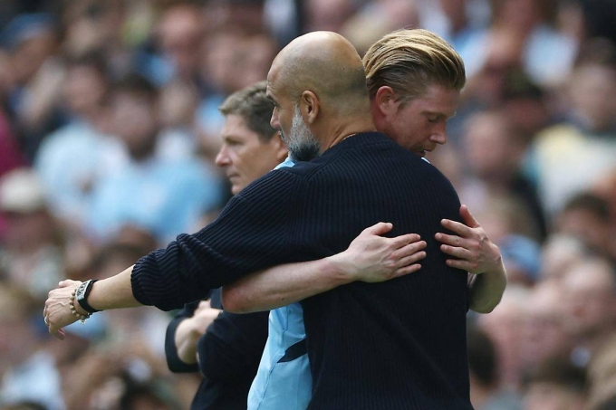 Guardiola (áo đen) ôm khi thay Kevin De Bruyne trong trận Man City 5-2 Crystal Palace ở vòng 32 Ngoại hạng Anh tối 12/4. Ảnh: Reuters