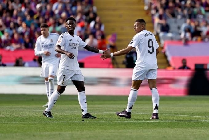 Vinicius bắt tay Mbappe sau khi kiến tạo cho đồng đội ghi bàn ở trận thua Barca 3-4 ngày 11/5. Ảnh: AS