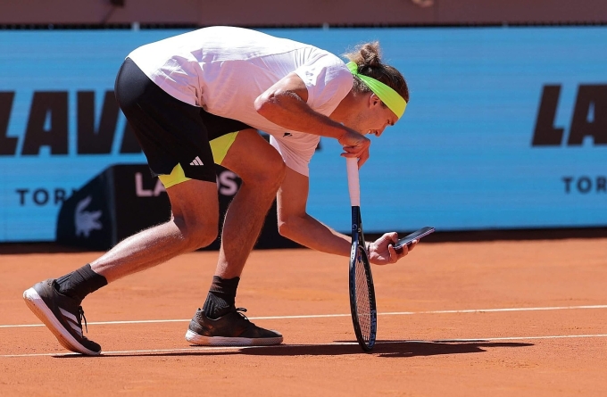 Zverev lấy điện thoại chụp vết bóng ở sân Trung tâm Madrid Mở rộng, khiến anh bị trọng tài cảnh cáo hôm 27/4. Ảnh: Reuters
