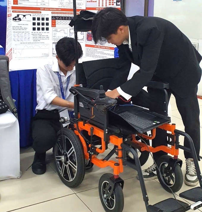Hiếu và Quân lắp đặt xe lăn tự hành để trưng bày tại cuộc thi Khoa học Kỹ thuật cấp quốc gia, tháng 3. Ảnh: Nhân vật cung cấp