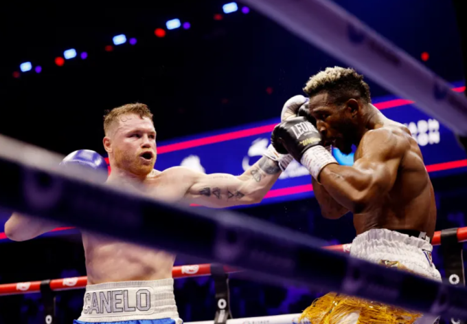 Canelo Alvarez (trái) tung cú đấm trúng mặt William Scull...