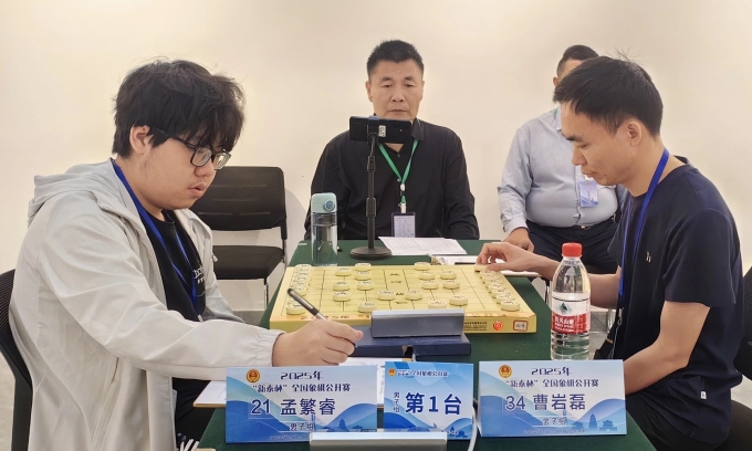 Mạnh Phồn Duệ (trái) trong trận chung kết giải Tân Thái gặp Tào Nham Lỗi, tại khách sạn quốc tế Vinh Phong, thành phố Tân Thái, tỉnh Sơn Đông, Trung Quốc ngày 18/5/2025. Ảnh: Baidu