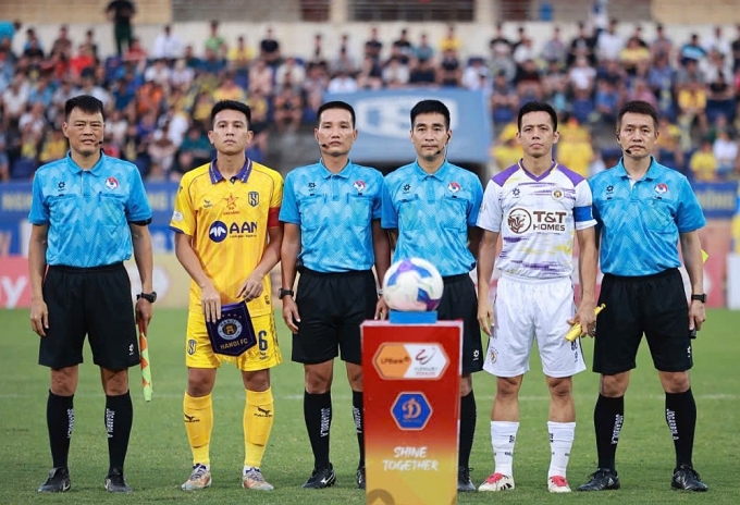 Trọng tài thứ tư Nguyễn Kim Việt Bảo và trọng tài chính Hoàng Thanh Bình (thứ ba và bốn từ trái sang) trong trận SLNA (áo vàng) thua Hà Nội FC (áo trắng) 1-2 ở vòng 22 V-League 2024-2025, trên sân Vinh, Nghệ An, ngày 10/5/2025. Ảnh: Xuân Thủy